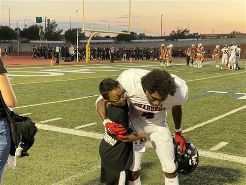 Kayden and Harold hugging on the sidelines